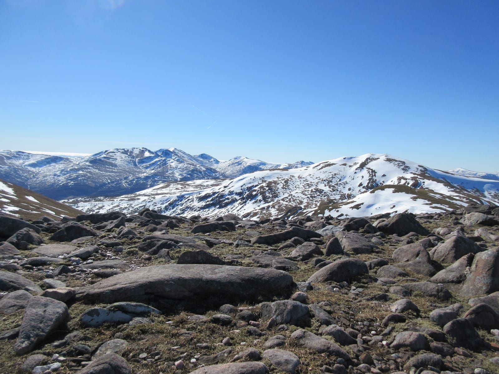 Looking back to Carn Gorm and snow-capped mountains beyond from the summit of Meall Garbh
