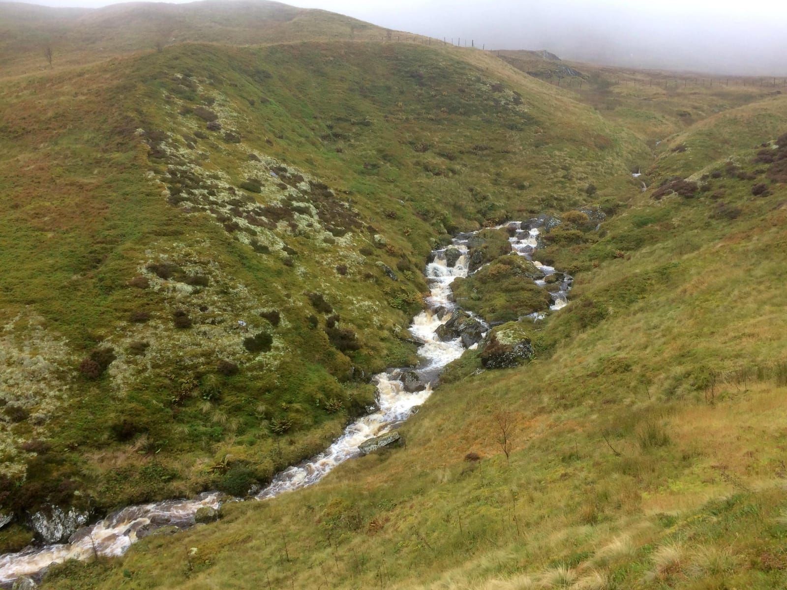 White water rushes down Coire Odhair during torrential rain on a walk in the Ben Lawers range