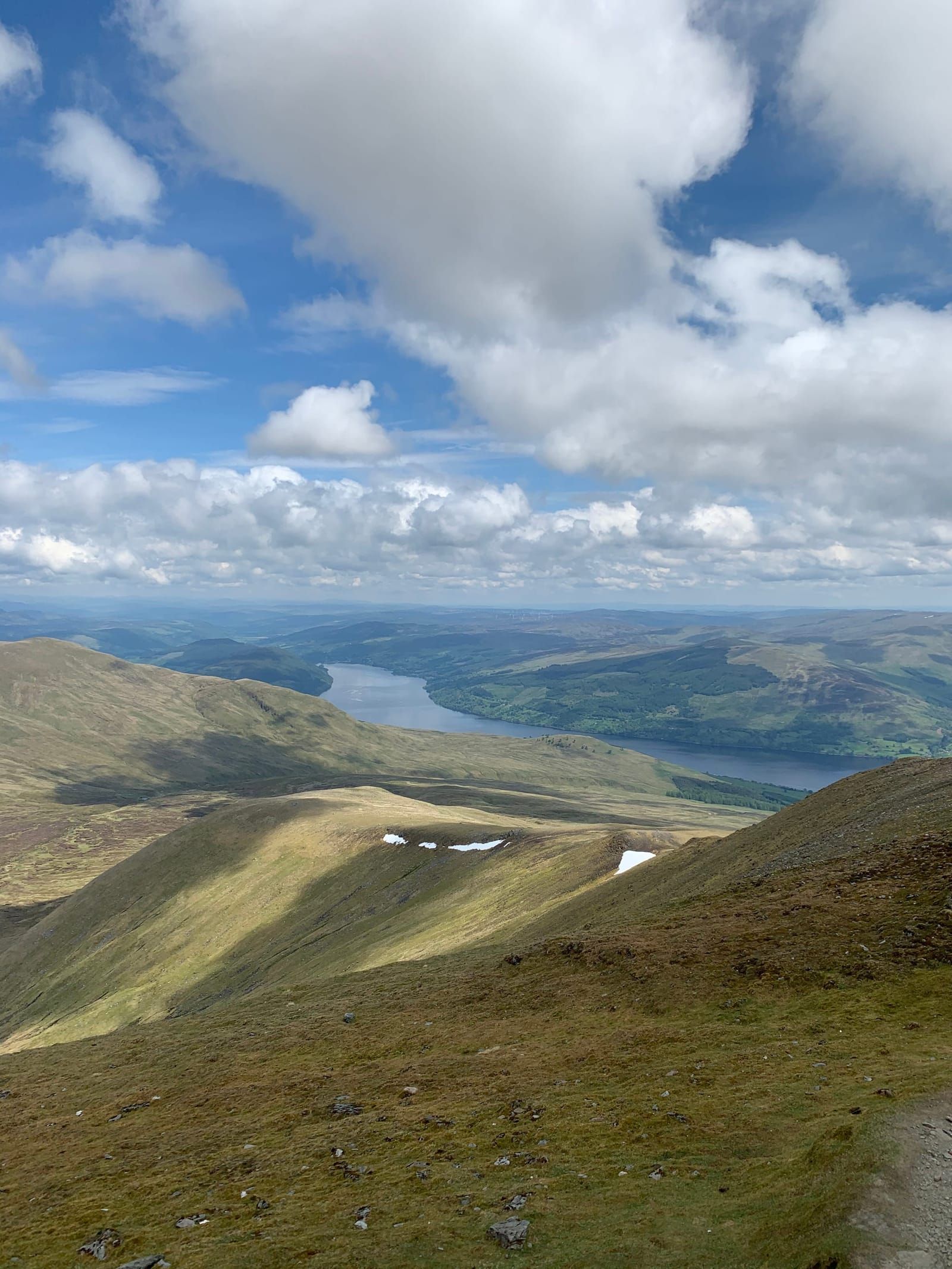 Hikers on a mountain trail overlooking a Scottish loch